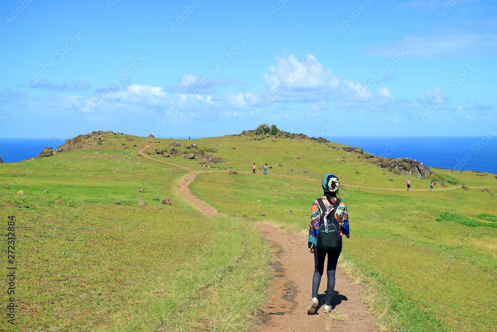 Fototapeta premium Female Tourist Visiting Orongo Village, the Historic Ceremonial Center on Easter Island, Chile