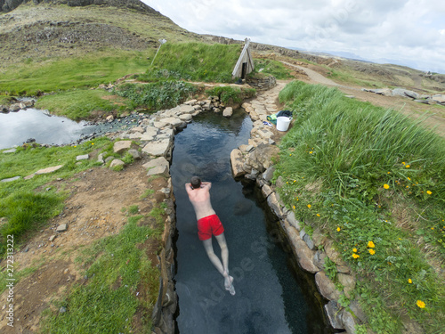 Man relaxing in a hot pool in Hrunalaug, Iceland photo