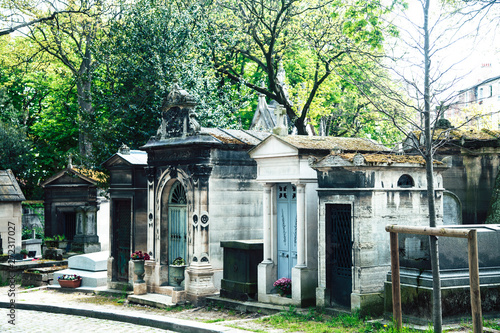 Tombstones in cemetery at dusk, gothic style crosses Paris