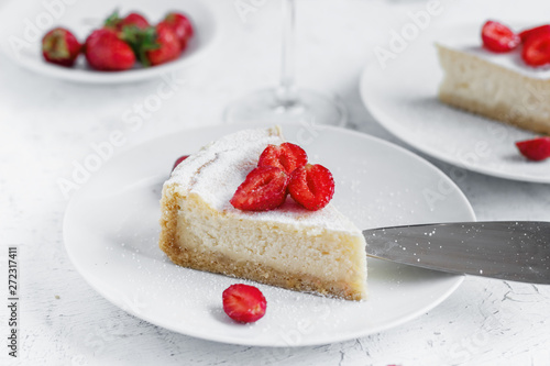 Cheesecake decorated with strawberries on a white plate