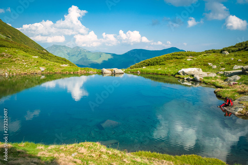 Hiker or photographer on the banks of a crystal clear lake in Romania