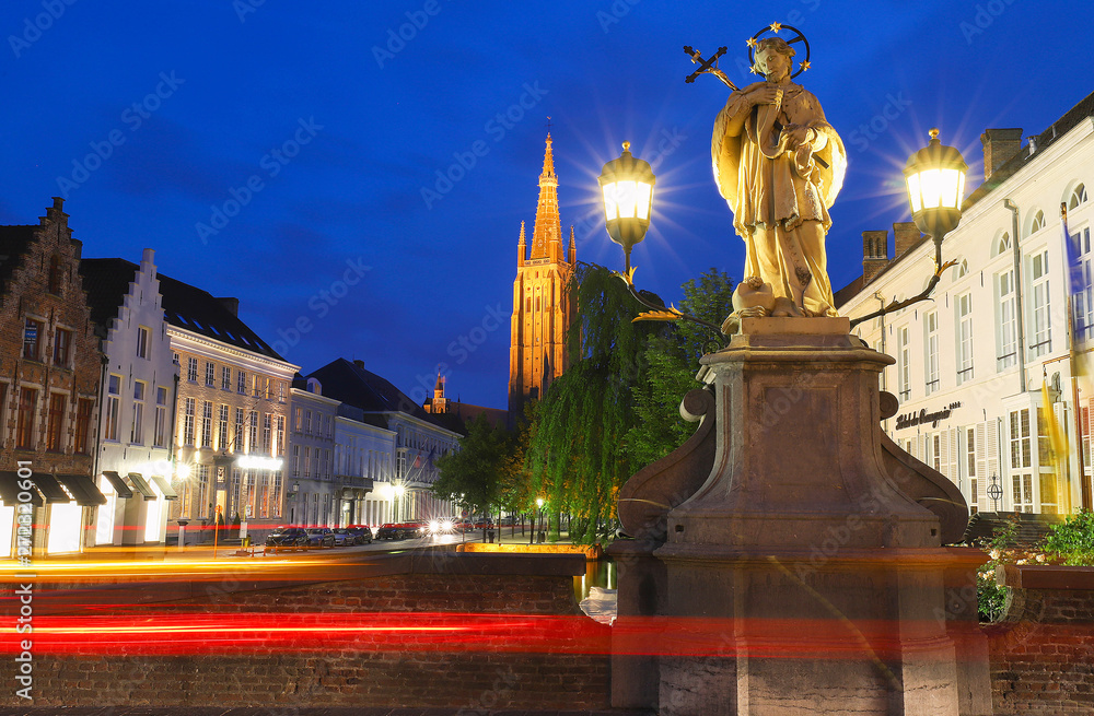 Fototapeta premium Scenic cityscape with a medieval fairytale canal, Bridge St. Nepomuk and the quay Dijver and Church of Our Lady in Bruges, Belgium