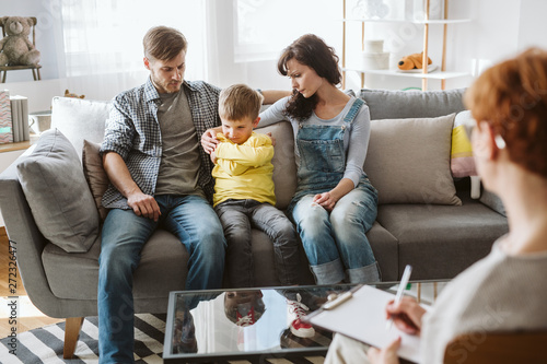 Foto Caring parents and misbehaving boy during therapy session with counselor