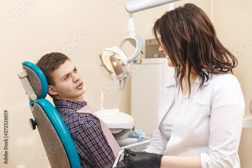 Photos Photo of young female dentist and young male patient in the dentist room