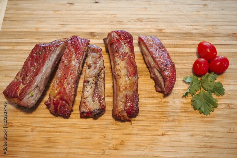 BBQ, Roasted pork ribs and delicious tomatoes, placed on a wooden tray. raw meat on a plate, 