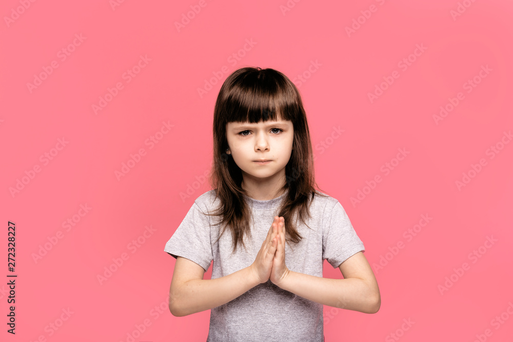 Child praying. Girl kid prays. Gesture of faith. Hands folded in prayer concept for faith, spirituality and religion, feels sad desperate, symbol of asking apologizing, sincere saying please concept Child praying. Girl kid prays. Gesture of faith. Hands folded in prayer concept for faith, spirituality and religion, feels sad desperate, symbol of asking apologizing, sincere saying please concept