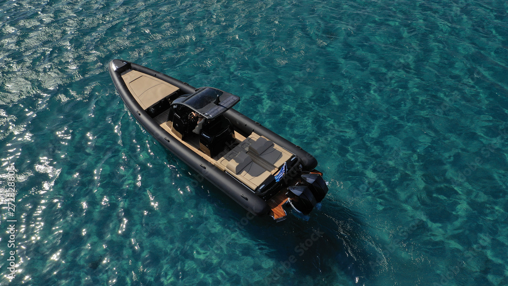 Aerial photo of high speed inflatable rib boat docked in turquoise and sapphire open sea near port of Mykonos island Aerial photo of high speed inflatable rib boat docked in turquoise and sapphire open sea near port of Mykonos island