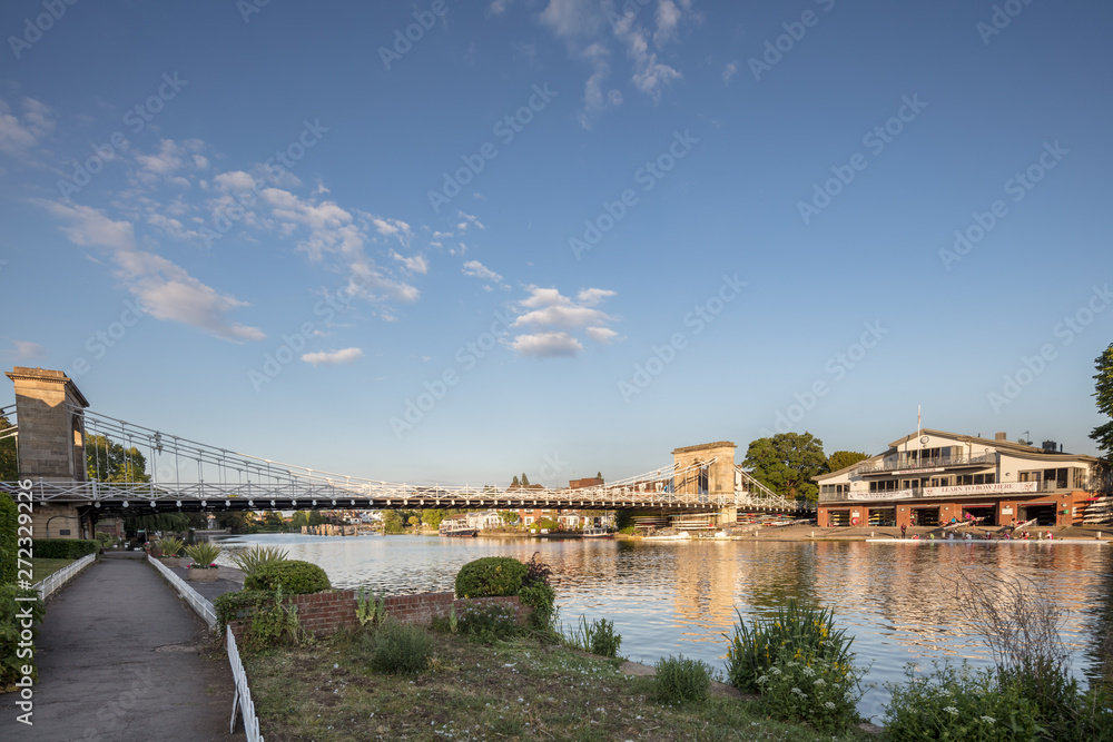 Marlow suspension bridge and the Marlow rowing club on the river Thames in Buckinhamshire, UK on a warm summer's evening
