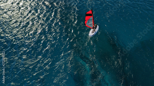 Aerial photo of surfer cruising in high speed in Mediterranean destination bay with deep blue sea