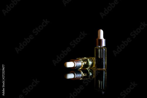 Blank glass cosmetic bottles on black background for print design and mock up