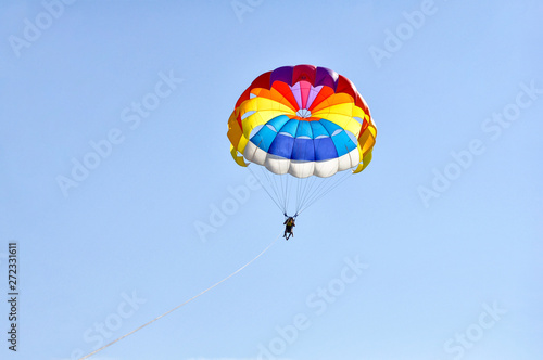 Para sailing using a parachute on background of blue sky.