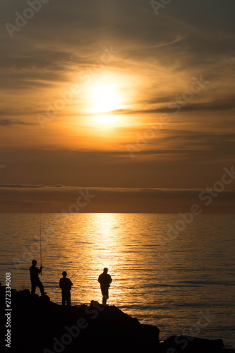 夕暮れの海と釣り人たち
