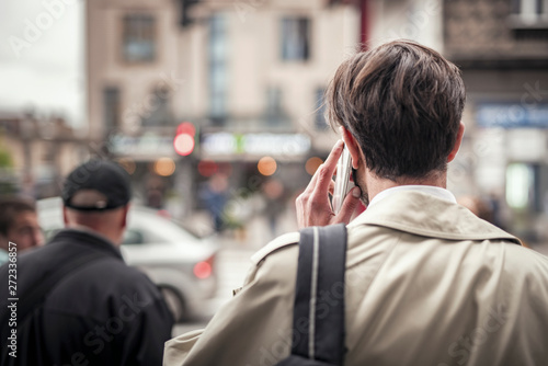 Tableau sur toile Young handsome business man chatting on his phone, waiting on the traffic light