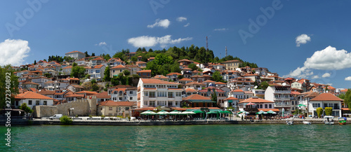 Fototapeta Naklejka Na Ścianę i Meble -  Ochrid, Macedonia: toursit walking and enjoing in the view of old part of Ochrid city on a boat dock on a Ochrid lake
