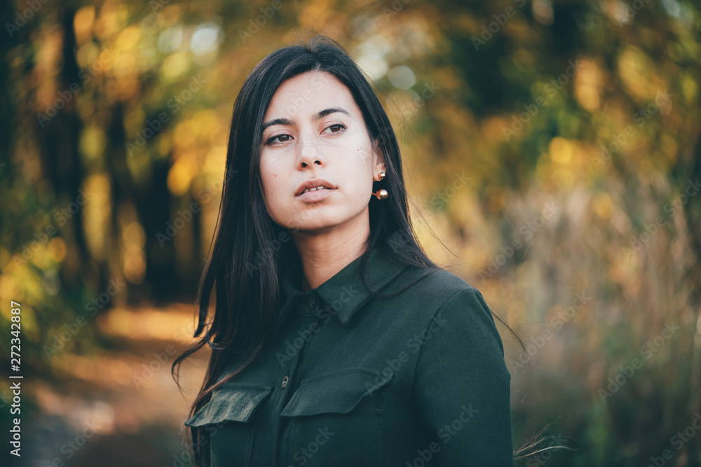 Female beauty portrait surrounded by vivid foliage. Dreamy beautiful girl with long natural black hair on autumn background with colorful leaves in bokeh. Inspired girl enjoys nature in autumn forest. Female beauty portrait surrounded by vivid foliage. Dreamy beautiful girl with long natural black hair on autumn background with colorful leaves in bokeh. Inspired girl enjoys nature in autumn forest.
