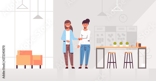 businesswomen handshaking business partners hand shake during meeting agreement partnership concept colleagues standing in creative co-working center modern office interior full length horizontal
