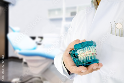 Dentist show orthodontic model  in his hand / in office or clinic.