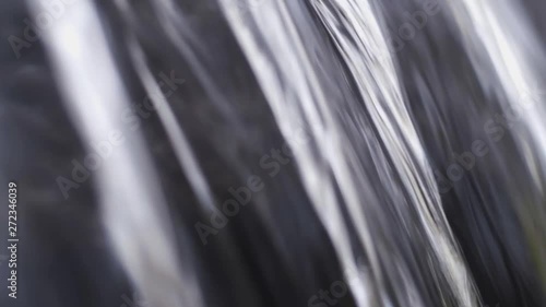 close up shot of flowing water coming from a small waterfall photo