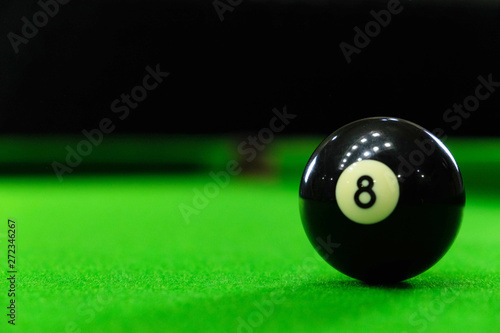 Close-up photos of billiard ball, number 8 and green floor