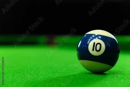 Close-up photos of billiard ball, number 10 and green floor