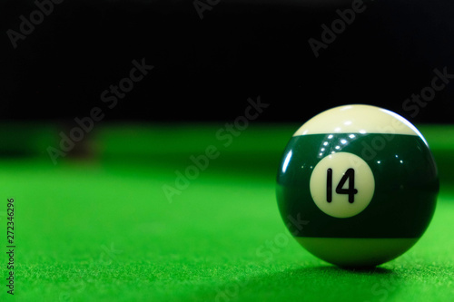 Close-up photos of billiard ball, number 14 and green floor