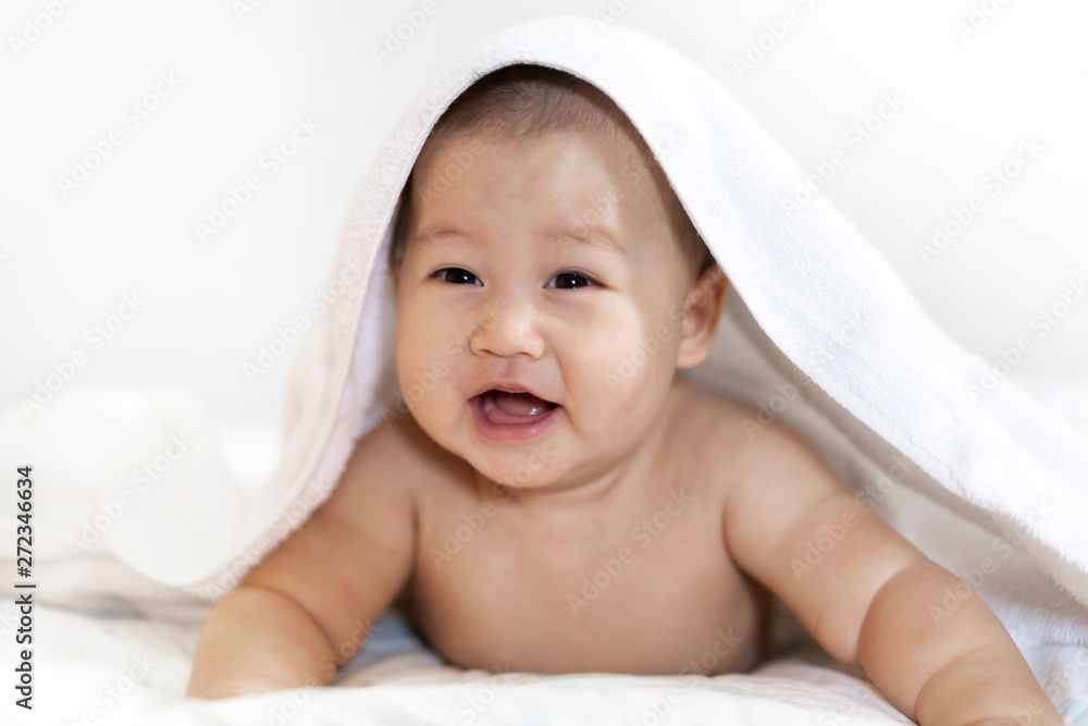 Portrait of happy smile baby relaxing under towel after bath on the bed Portrait of happy smile baby relaxing under towel after bath on the bed