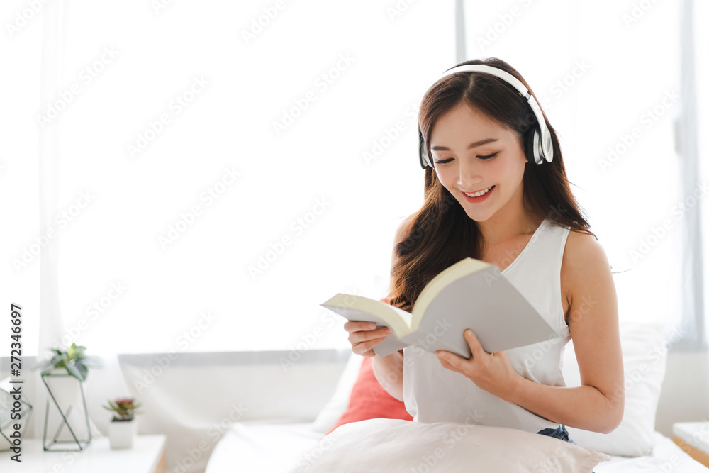 Young woman relaxing and reading book on bed at home Young woman relaxing and reading book on bed at home