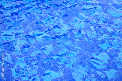 wave of swimming pool water surface. open water body blown by strong wind causing wave and ripple. blue ceramic tiles floor.