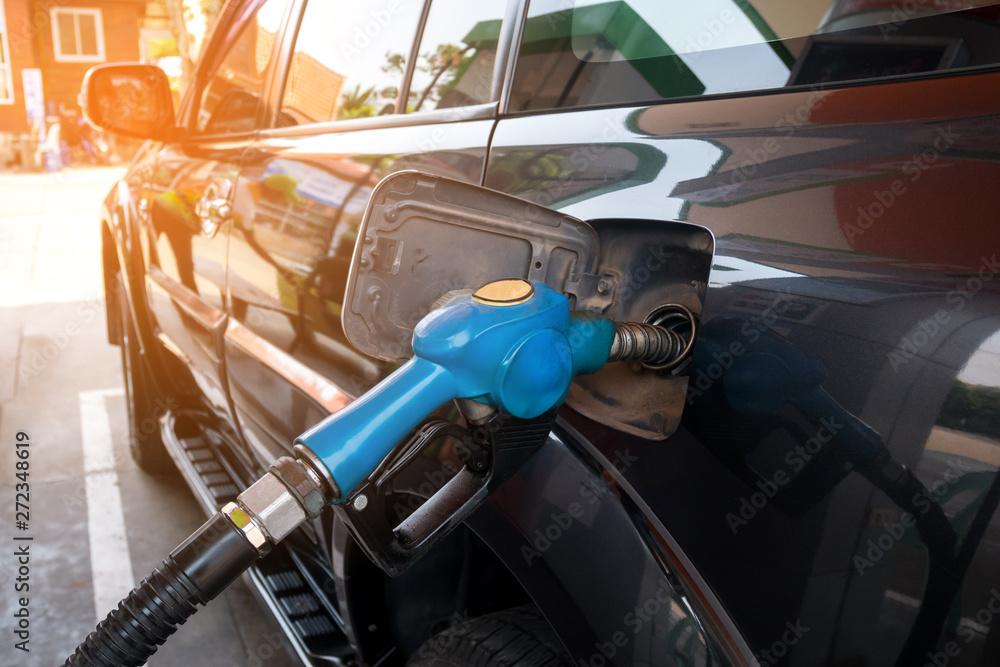 Fuel oil gasoline dispenser at petrol filling station.Holding fuel nozzle to refuel gasoline for car. Fuel oil gasoline dispenser at petrol filling station.Holding fuel nozzle to refuel gasoline for car.