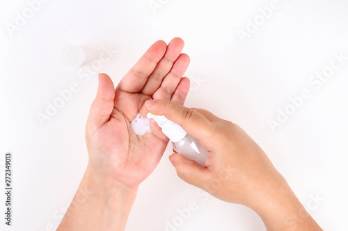 Girl uses hand cream on white background. Top view.