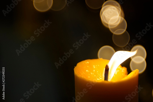 Bright flame from a burning candlewick with bubble blur background