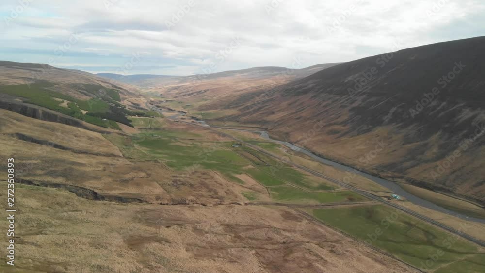 Aerial view over the beautiful landscape in the eastern part of Iceland, showing multiple fields, a river and a road leading in through a canyon between big mountains Aerial view over the beautiful landscape in the eastern part of Iceland, showing multiple fields, a river and a road leading in through a canyon between big mountains
