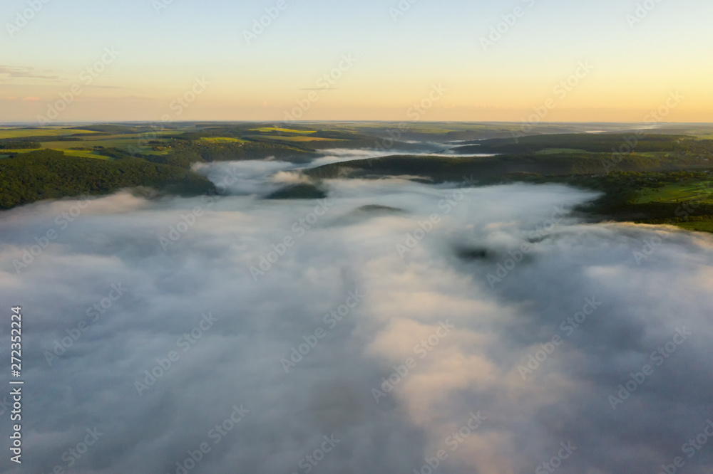 Canyon river in fog shooting from the air