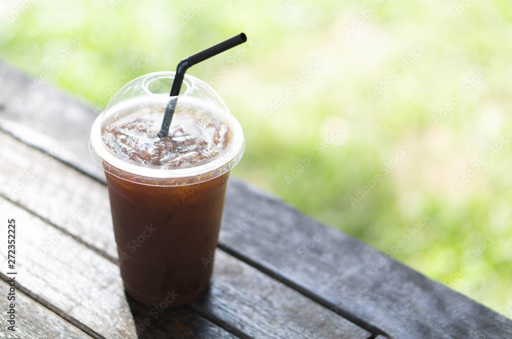 Close up glass of ice americano coffee on wood table, selective focus Close up glass of ice americano coffee on wood table, selective focus
