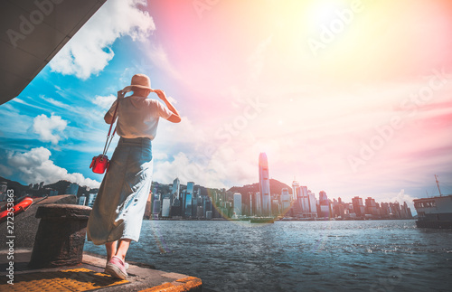 Photography Asian woman wear straw hat look at Victoria Harbor from Tsim Sha Tsui