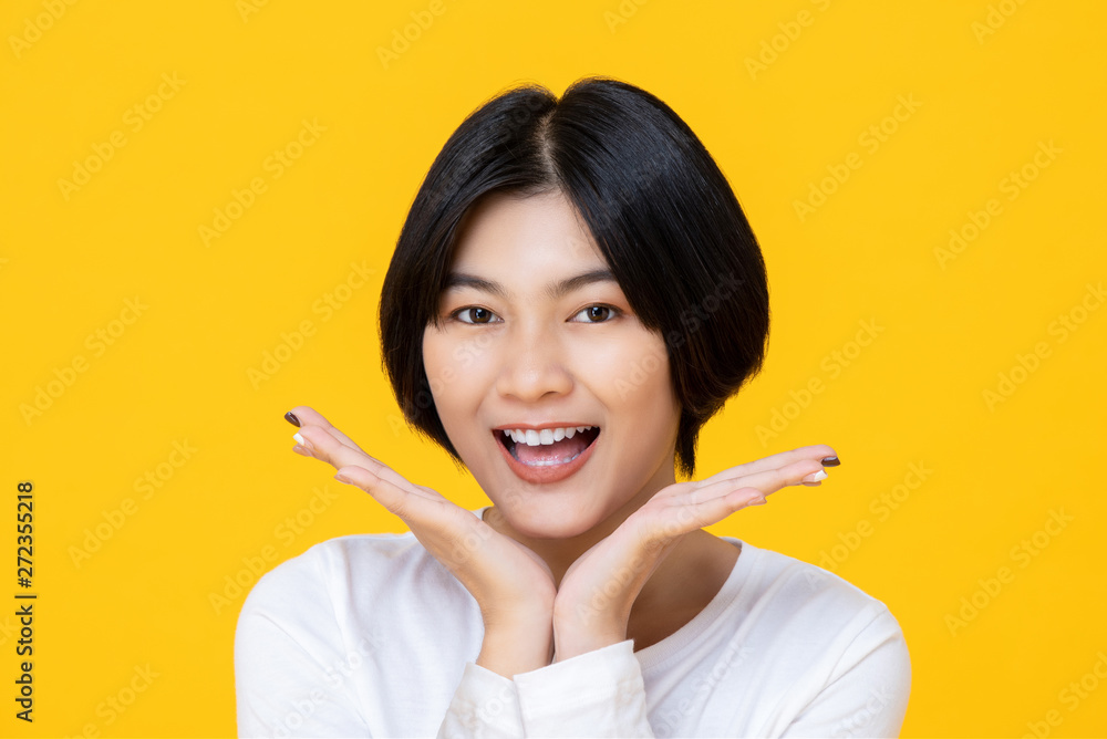 Cheerful nice smiling woman placing her happy face between hands Cheerful nice smiling woman placing her happy face between hands