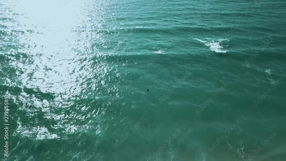 Surfers waiting for the perfect wave in crystal clear waters. Surfers waiting for the perfect wave in crystal clear waters.