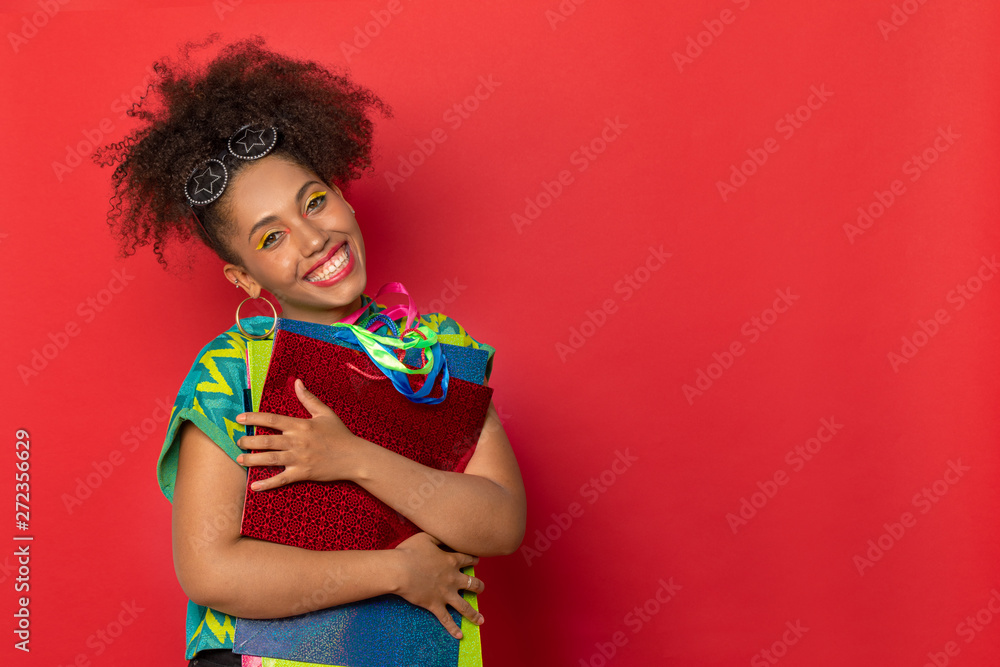 dark-skinned and curly girl with colored bags for shopping in stores. waiting for new purchases. girl on red Studio background dark-skinned and curly girl with colored bags for shopping in stores. waiting for new purchases. girl on red Studio background