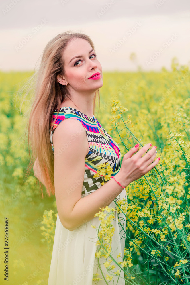 beautiful boho girl posing on camera in canola field beautiful boho girl posing on camera in canola field