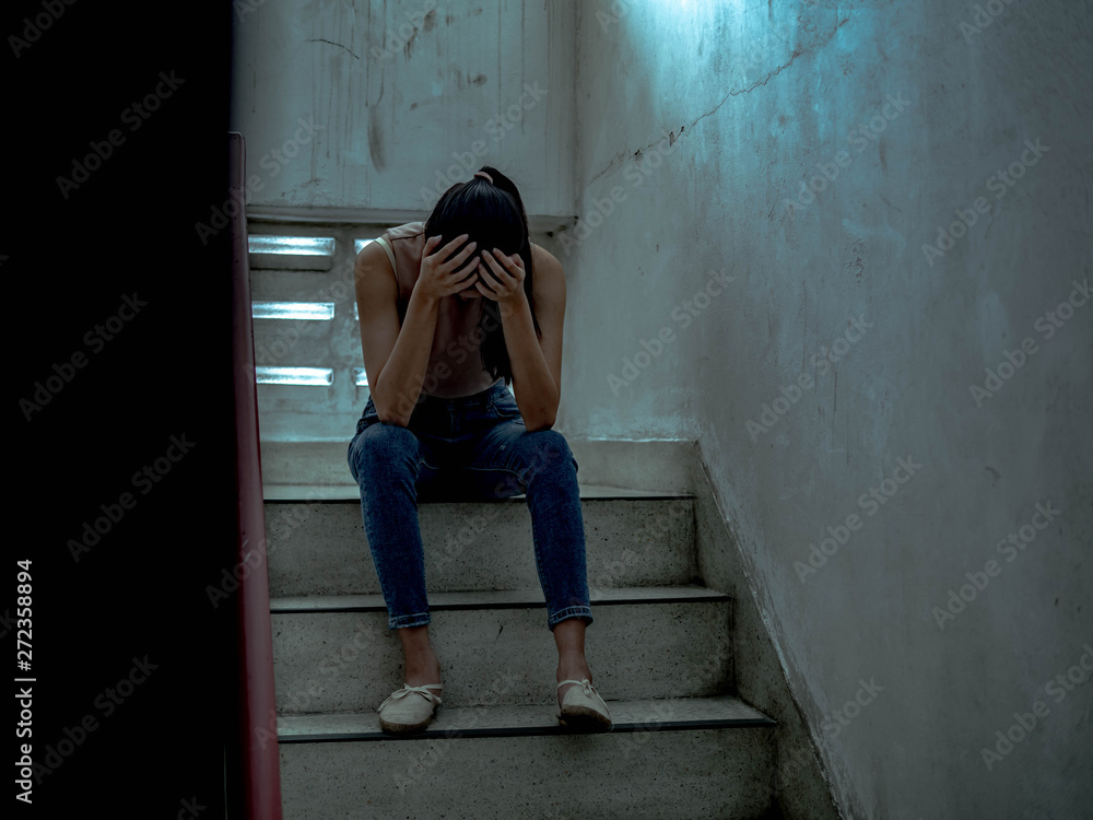 Unhappy depressed teenager with face in hands sitting stair, thinking about problem with relationships or work, feeling despair and anxiety, loneliness, having psychological trouble.