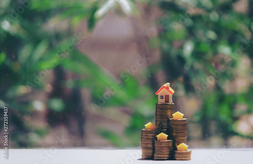 A small house on a pile of coins is used as an asset, financial concept for mortgage, financial investment fund and home loan, interest rate. photo