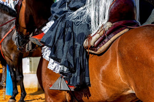Woman riding a horse with the typical Andalusian costume, Spain