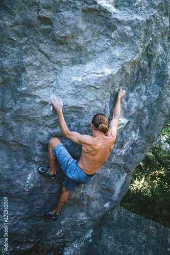 Man climbing boulder.