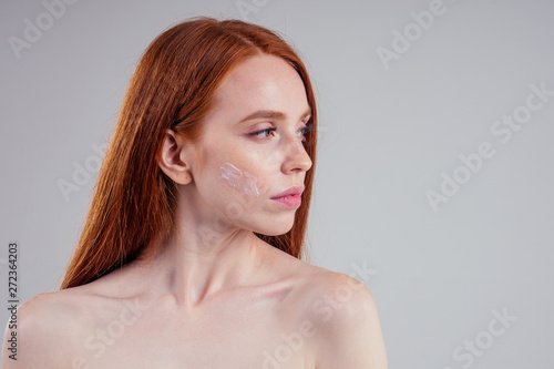 fashion portrait of redhead model nude with perfect skin studio on white background.