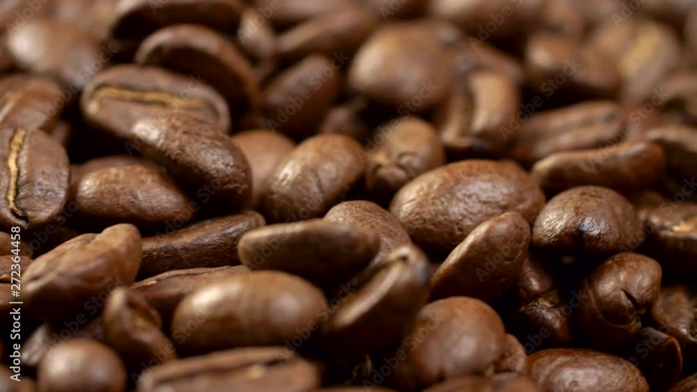 Brown appetizing roasted coffee beans on a rotating panel. Close-up shot, 4K Brown appetizing roasted coffee beans on a rotating panel. Close-up shot, 4K