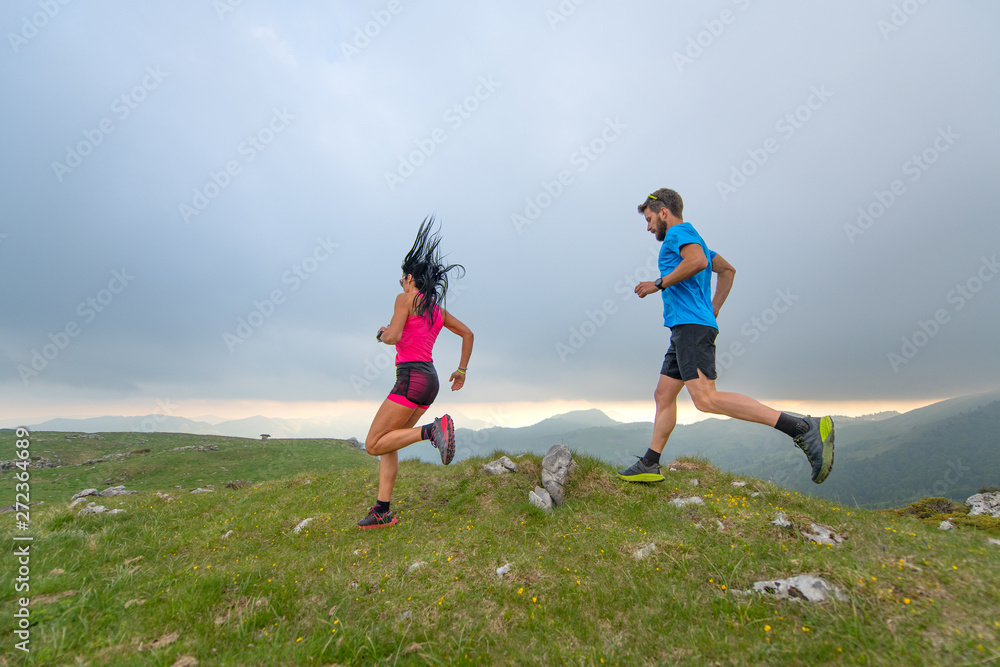 Couple of man and woman mountain athletes runners in action Couple of man and woman mountain athletes runners in action
