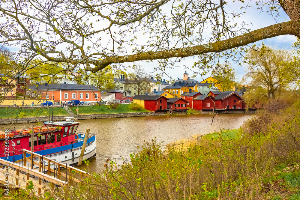 Scenic view of the Finnish city of Parvoo. River pleasure boat. Neat outbuildings. Spring nature. Multicolored buildings along the city promenade. Scenic view of the Finnish city of Parvoo. River pleasure boat. Neat outbuildings. Spring nature. Multicolored buildings along the city promenade.
