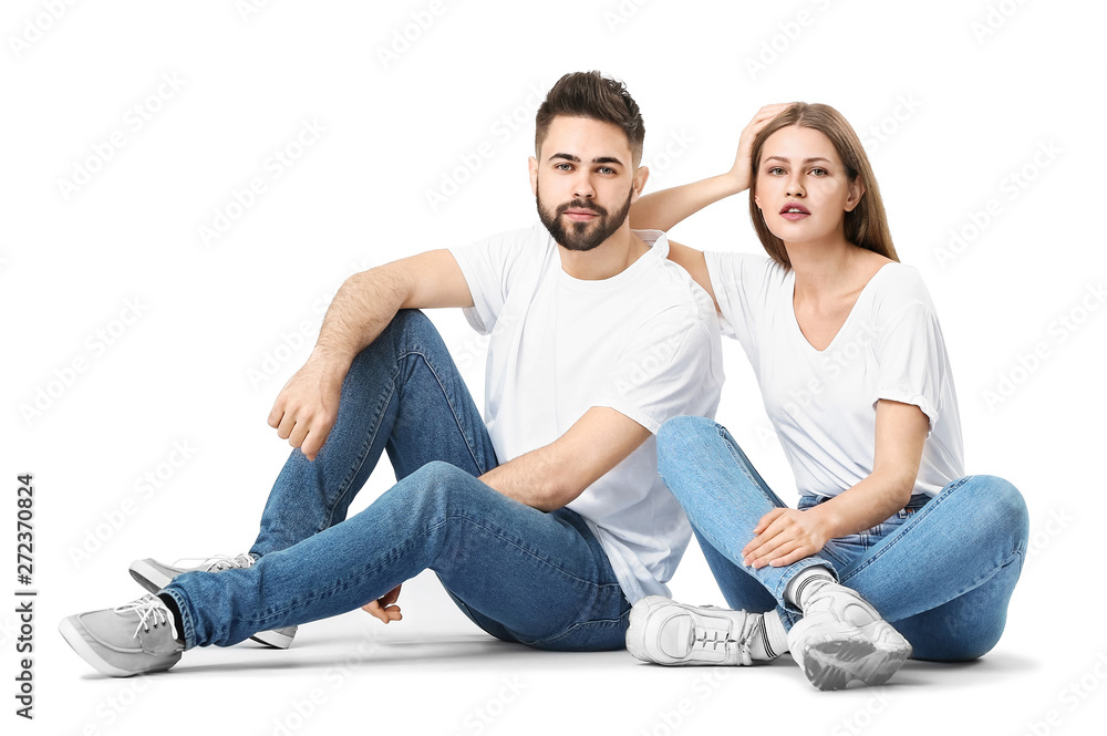 Stylish young couple in jeans on white background