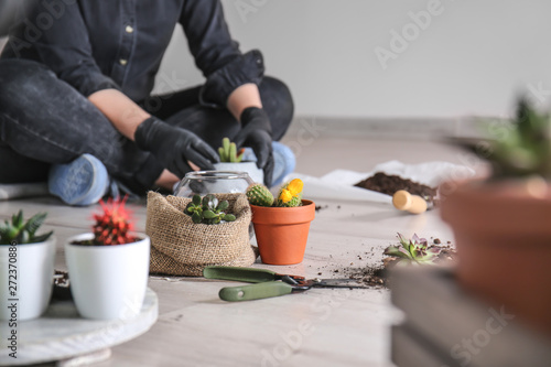 Woman transplanting succulents on floor