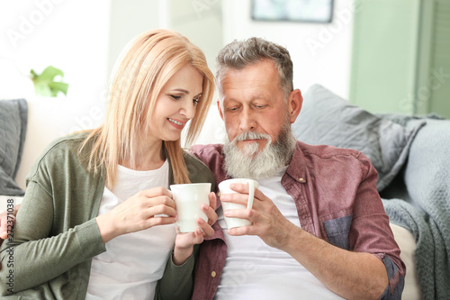 Happy elderly couple drinki...